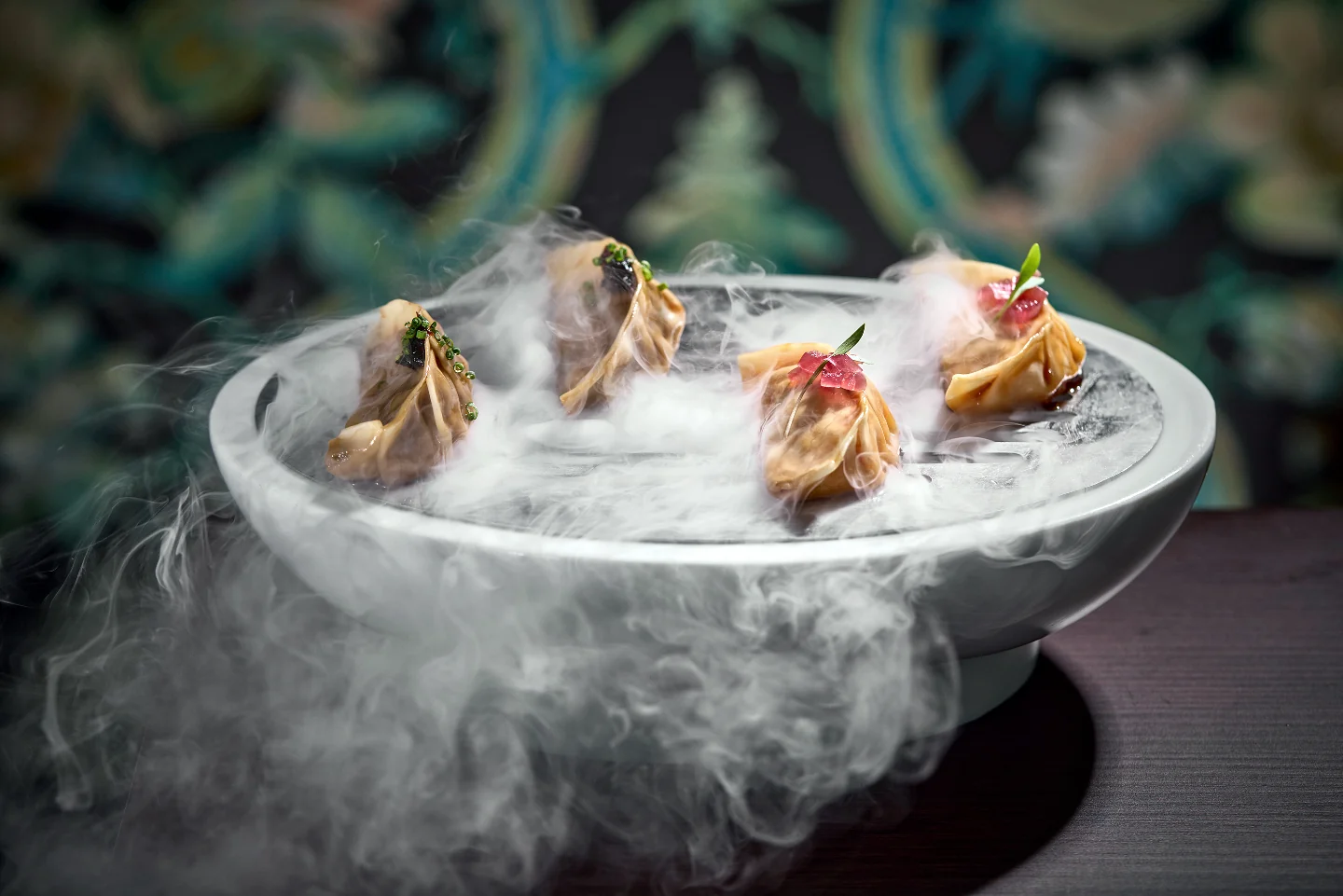 Gyozas servidas sobre un cuenco con humo de hielo seco